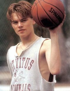 a young man holding a basketball in his hand