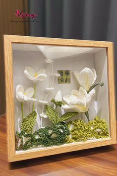 a wooden frame with flowers in it on a table