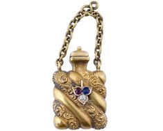 An antique Victorian 14K gold perfume bottle, circa the mid 19th century. The piece is modeled as a miniature vessel of a gadrooned square shape, adorned with fine hand carved patterns and set with a ruby, a sapphire and a diamond to the front side. Features a hinged lid and a separate chain intended to use the piece as an accessory. Unmarked. Collectible Victorian Era Jewelry, Vanity Items, Stamps And Seals. Total weight: 5.28 g. OVERALL GOOD VINTAGE CONDITION. SIGNS OF WEAR AND AGE. REFER TO P Victorian Era Jewelry, Antique Charm Bracelet, Jewelry Vanity, Gold Perfume, Diamond Charm Necklace, Yin Yang Charm, Vintage Charm Bracelet, Antique Bracelets, Bottle Charms