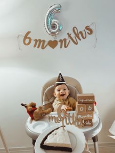 a baby in a highchair with a birthday cake