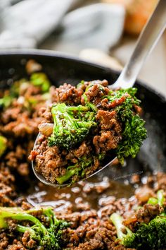 broccoli and ground beef in a skillet being held by a ladle