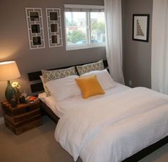 a bed with white sheets and pillows in a bedroom