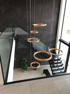 an indoor stair case with circular lights hanging from it