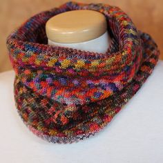 a multicolored knitted cowl on a mannequin headdress