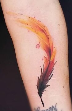 a colorful feather tattoo on the left forearm and arm with writing below it that reads,'born to me '