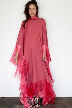 Peony Mrs. Ross Caftan from Taller Marmo Pink caftan dress with matching fringe Cut from fluid crepe with an elegant drape Fixed neck sash with fringe detailing Satin neck closes in back with single button 78% acetate, 22% viscose One size Made in Italy Model Measurements & Item Sizing: Model Height: 5'8” Model size: US 2 / S / 26 Size shown on model: one size Chic Fringed Floor-length Dress, Elegant Long Sleeve Kaftan With Tassels, Evening Kaftan With Tassels, Fringe Floor-length Maxi Dress, Spring Kaftan With Fringe, Long Evening Dress With Fringe, Chic Long Dresses With Fringe, Elegant Pink Dresses With Tassels, Elegant Pink Tassel Dresses