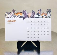 a calendar with cats sitting on top of it