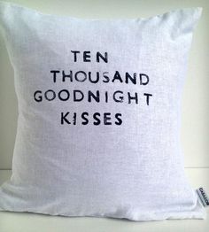 a white pillow with the words ten thousand goodnight kisses on it