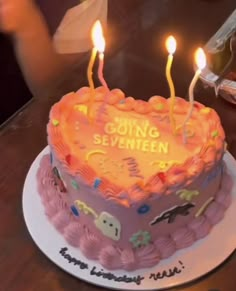 a heart shaped birthday cake with lit candles on it that says going seventien