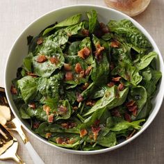 a white bowl filled with spinach and bacon