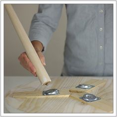 a person is using a hammer to cut wood pieces on a table with other tools