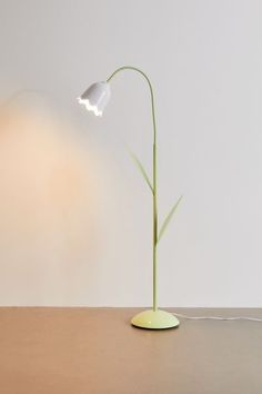 a lamp that is sitting on top of a table in front of a white wall