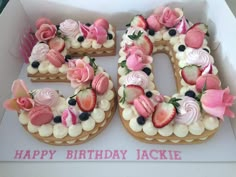 a birthday cake in the shape of the number 50 with strawberries and flowers on it