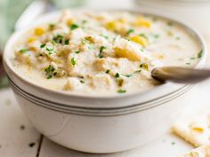 a white bowl filled with soup next to crackers