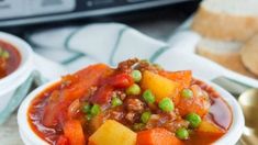 two bowls filled with stew and bread on top of a table