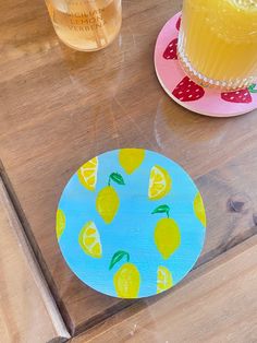 a wooden table topped with plates and cups filled with liquid next to a glass of orange juice