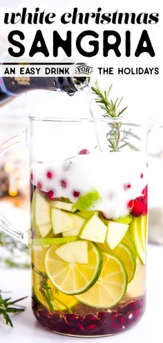 a pitcher filled with sangria and garnished with lemons, apples, cranberries, and rosemary