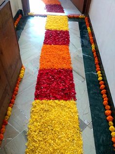 a long row of flowers on the floor in front of a doorway with an open door