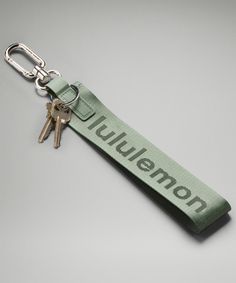 a green keychain with the word lutton on it and two keys attached to it