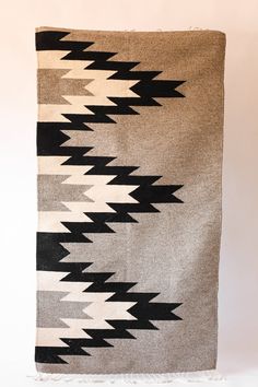 an old black and white blanket hanging on a wall