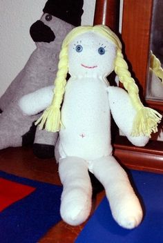 a white stuffed doll sitting next to a mirror