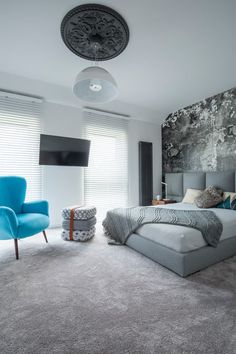 a large bed sitting in the middle of a bedroom next to a chair and window