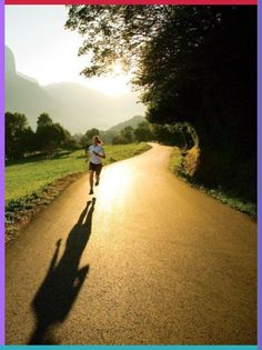 a person running down a road with the sun shining on them