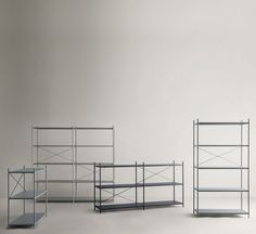 three metal shelvings and two shelves against a white wall with no one in it