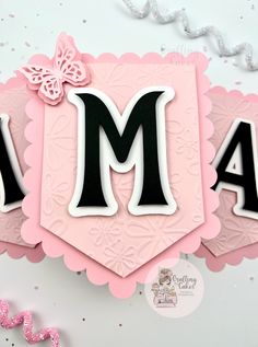 a pink and black card with the letter m on it