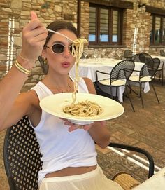 a woman sitting at a table with a plate of food