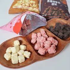 three wooden spoons filled with different types of food on top of a white table