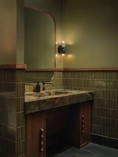 a bathroom sink sitting under a mirror next to a wall mounted faucet with lights on it