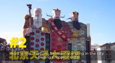 there are two large statues in front of the building with words above it that read, no 2 is the fortune sanwaan standing in the city being emperor hotel