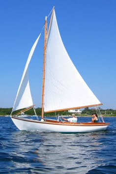 a sailboat with two people on it in the water