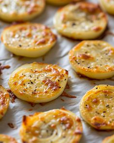 baked potato rounds with cheese and seasoning sitting on a baking sheet, ready to be eaten