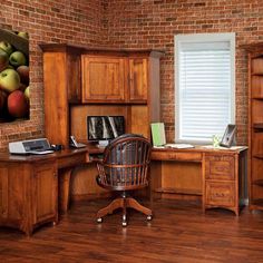 an office with wooden furniture and brick walls