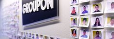 a groupon logo is displayed on a wall with many pictures of people in it