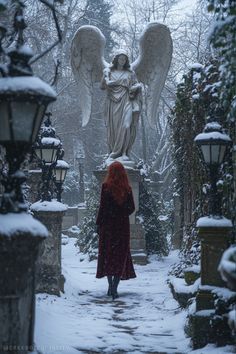 an angel statue is in the middle of a snowy path with lights on either side