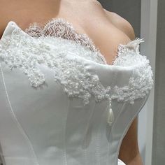 the back of a white wedding dress with beading and appliques on it