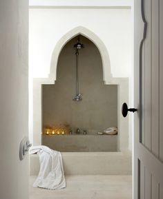 an open door leading to a bathroom with a bathtub and towel on the floor