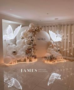 a room with balloons and flowers on the floor, in front of a white wall