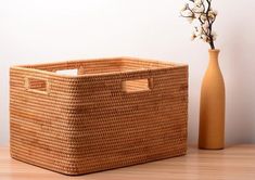 a wicker basket next to a vase on a table