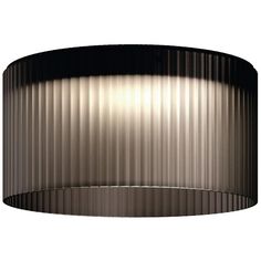 a round light fixture with pleated metal covering on the bottom, and a white background