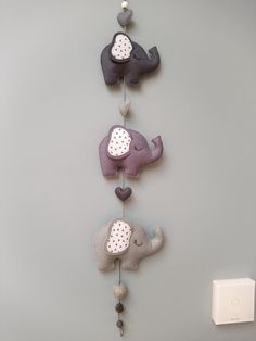 three stuffed elephants are hanging on the wall