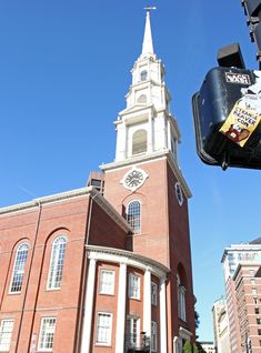 an old brick church with a steeple in the background