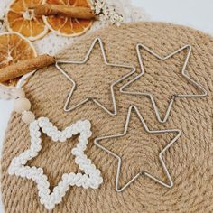 three star shaped cookie cutters sitting on top of a table next to an orange slice