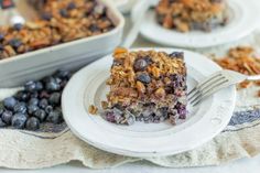 a piece of blueberry crumble cake on a plate with a fork next to it