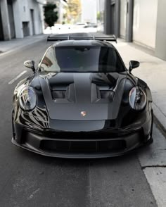 a black sports car is parked on the street