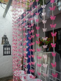 pink and white butterflies hanging from the side of a building