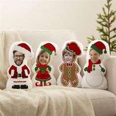 four decorative christmas pillows on a couch in front of a christmas tree with three smiling people